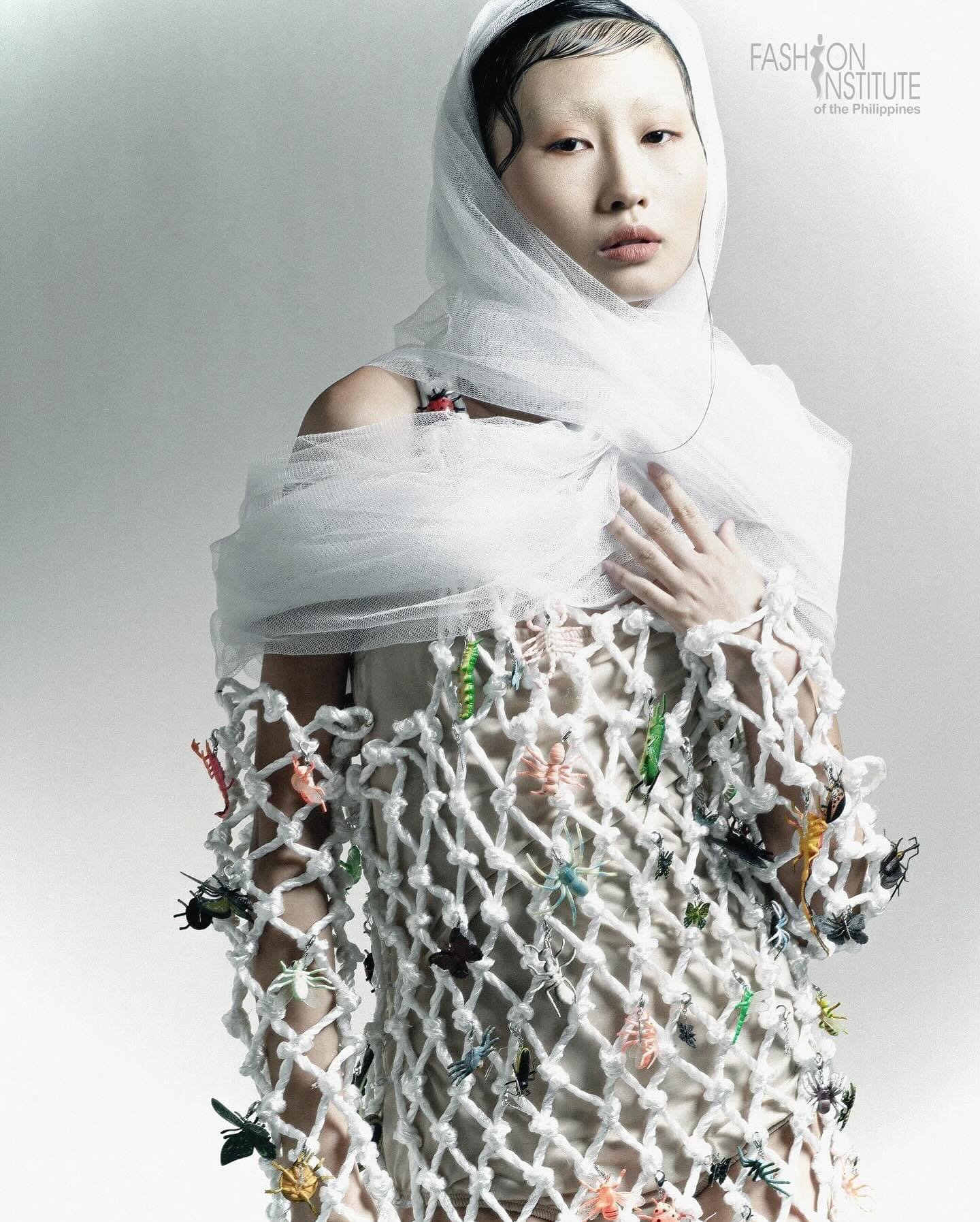 Minimal editorial makeup with sculpted wet-look hair and a sheer white headpiece