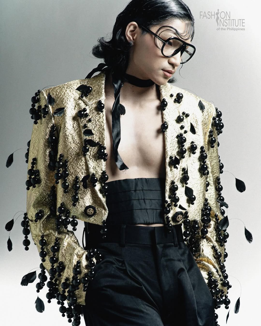 Bold editorial makeup with graphic wet-look hair styling for a menswear fashion shoot