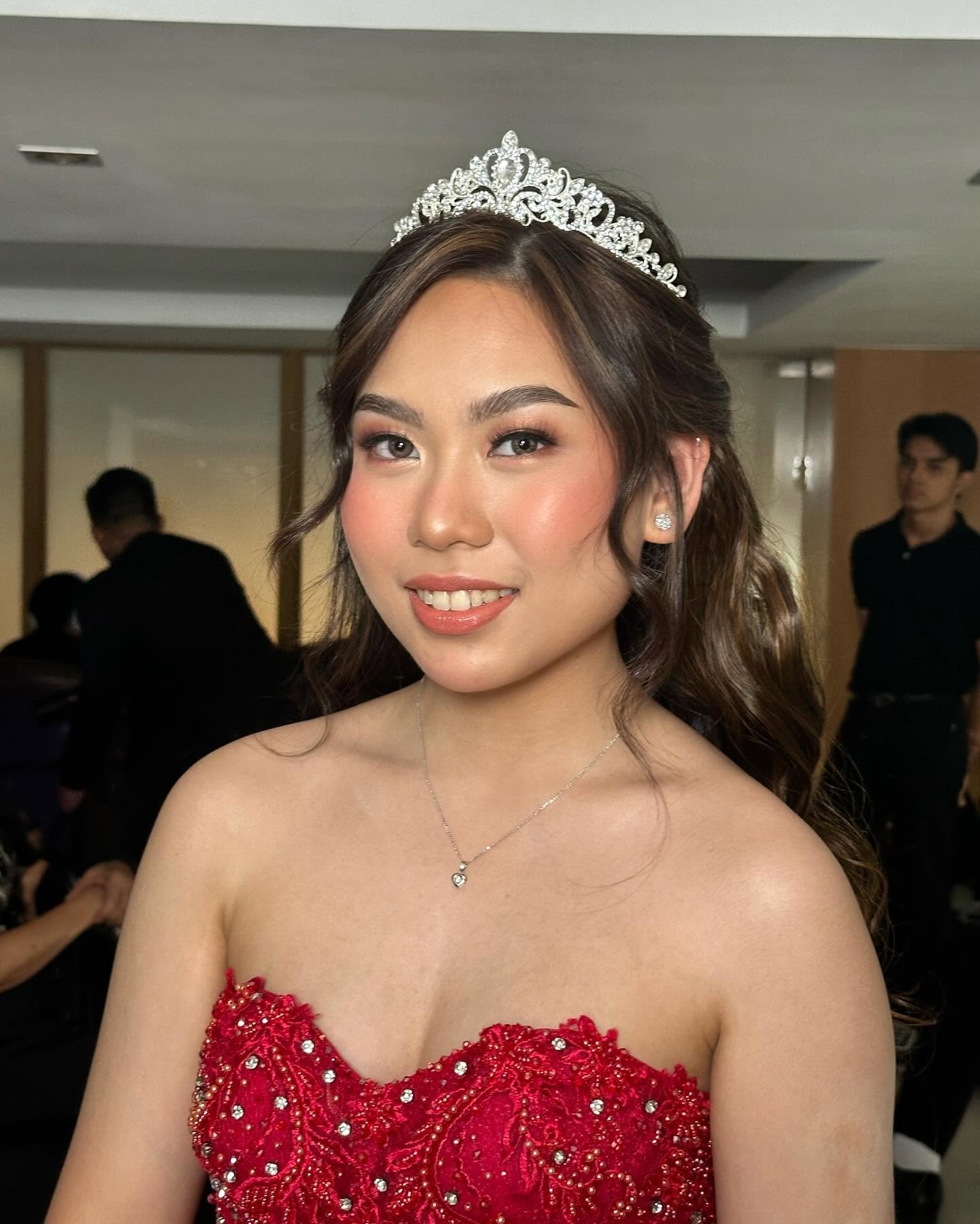 Debutante glam makeup look with a tiara and warm tones